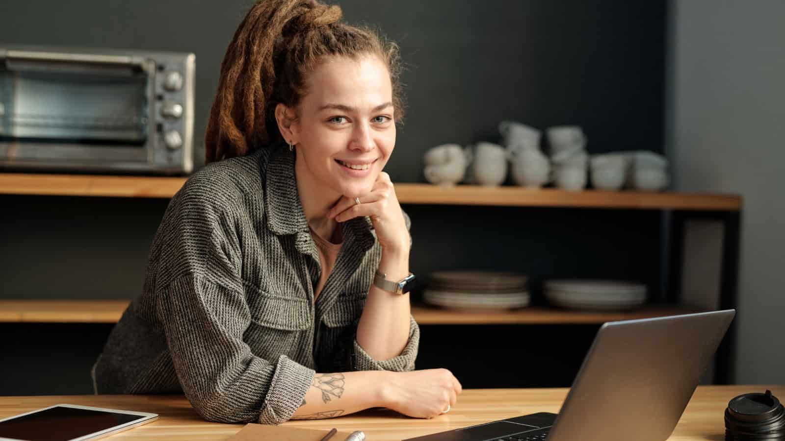 Confidant solopreneur sitting at her desk with a look of satisfaction because she works alone